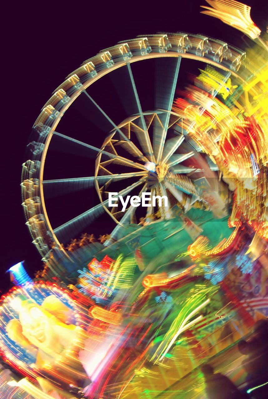 LOW ANGLE VIEW OF ILLUMINATED FERRIS WHEEL AT NIGHT