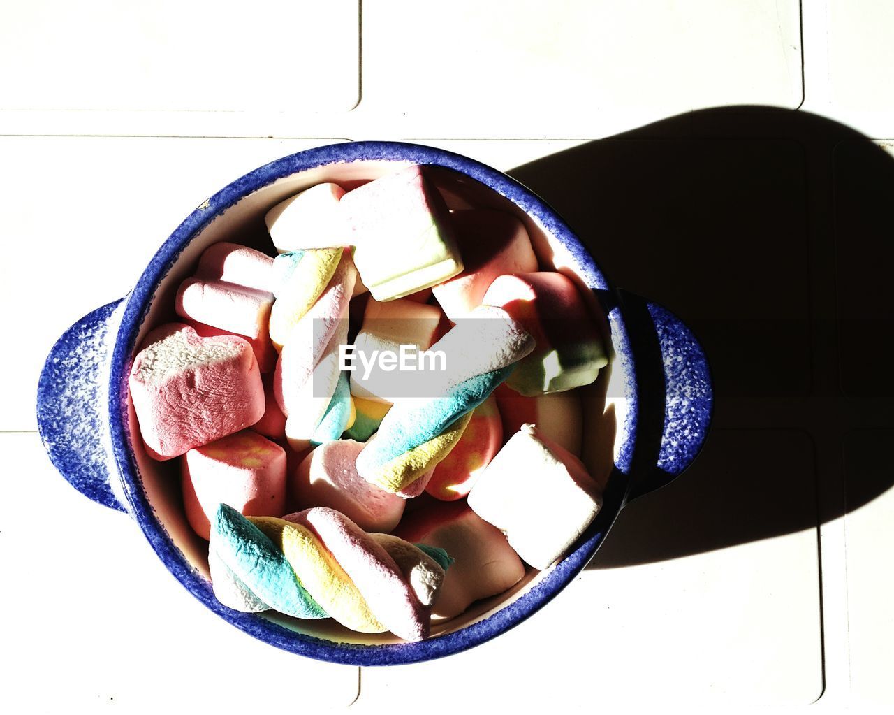 High angle view of candies in container on table during sunny day
