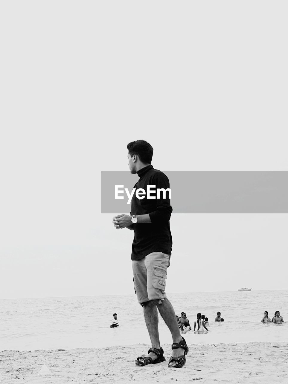 Full length of man standing at beach against clear sky