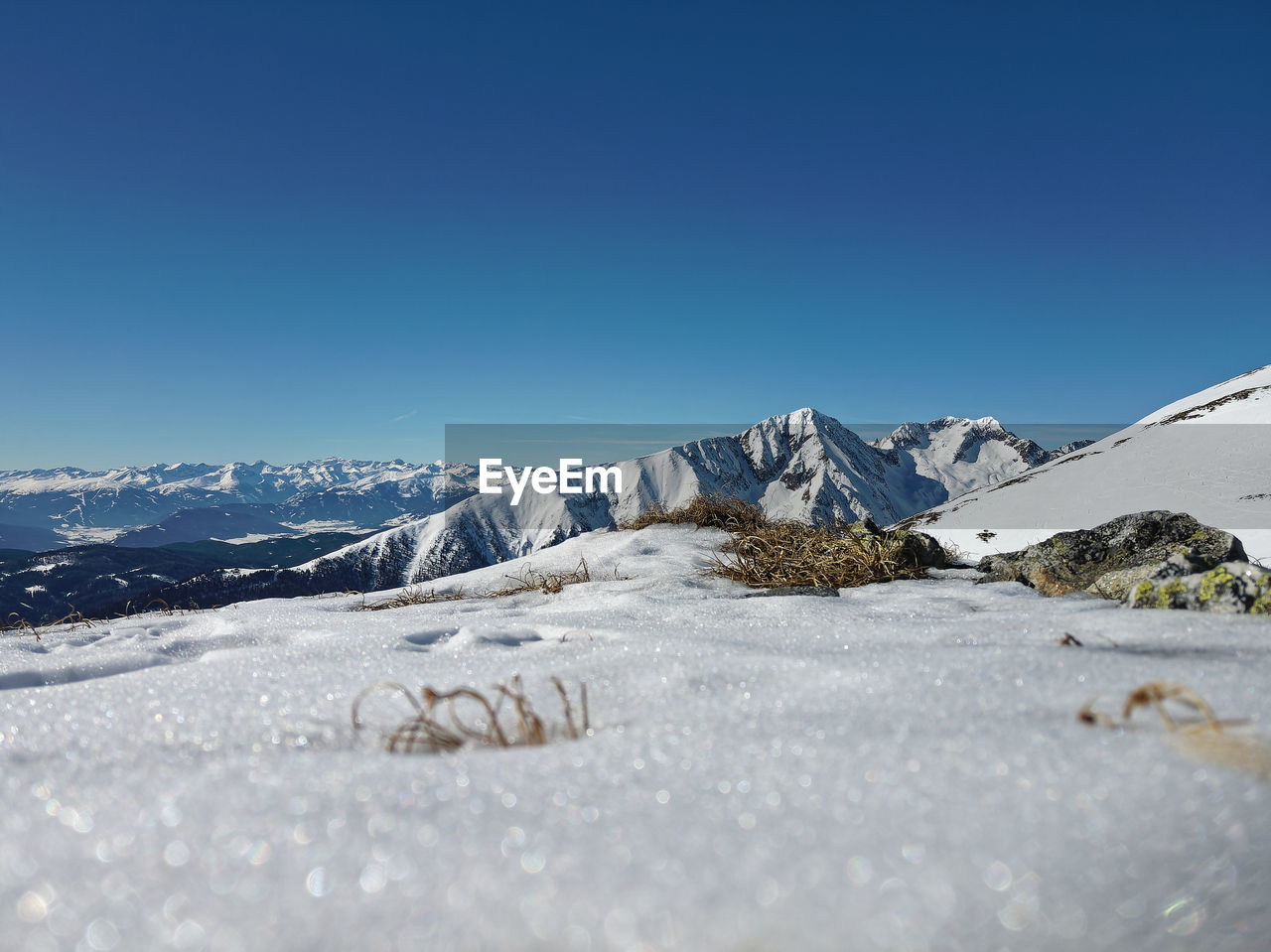 Scenic view of snowcapped mountains against clear blue sky