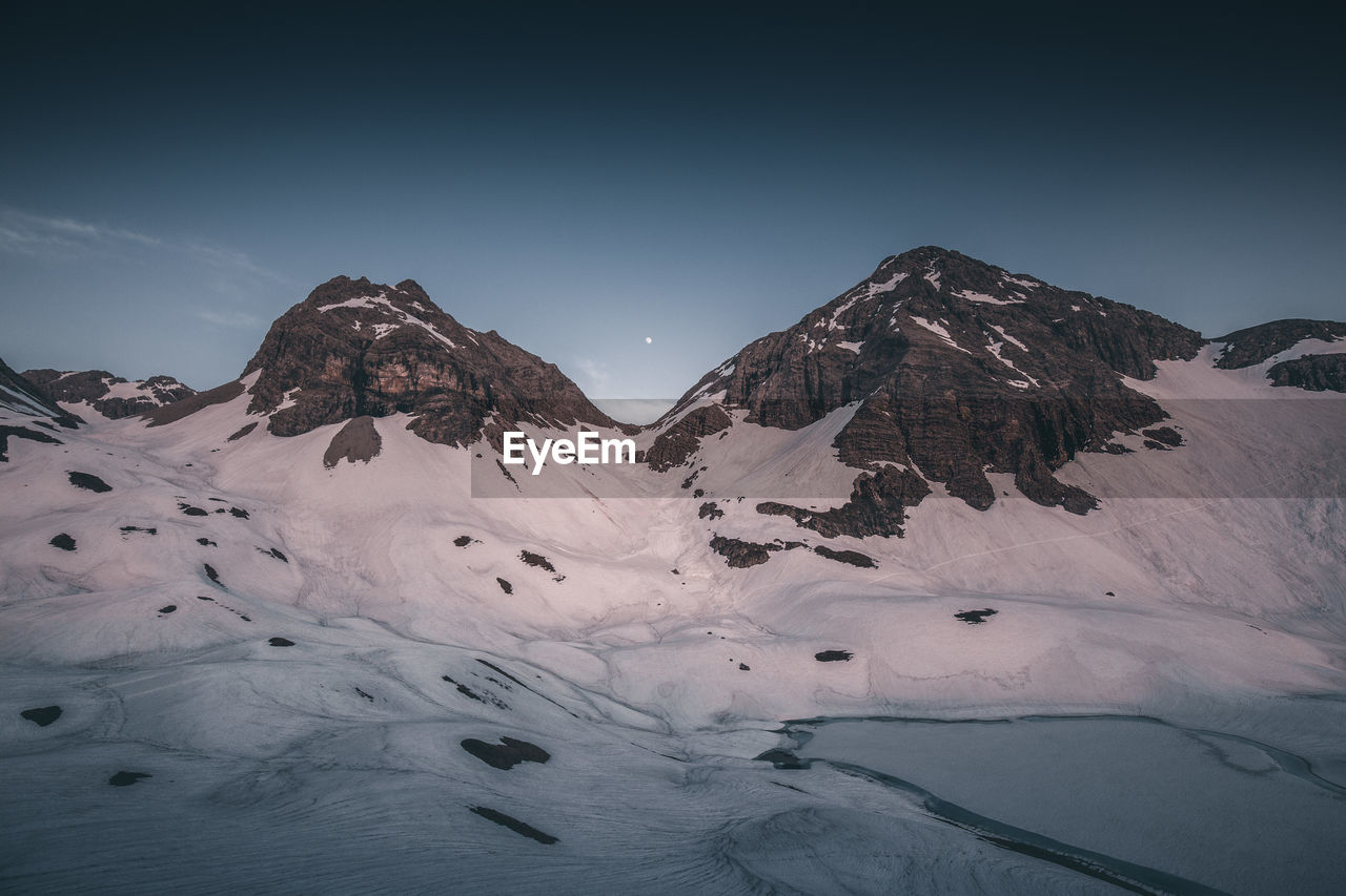 Scenic view of snow covered mountain against sky