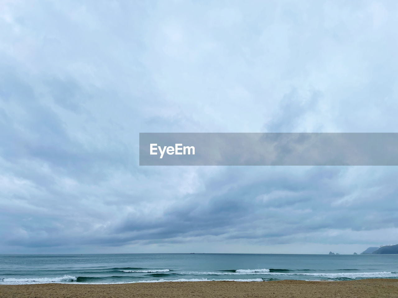 SCENIC VIEW OF BEACH AGAINST CLOUDY SKY