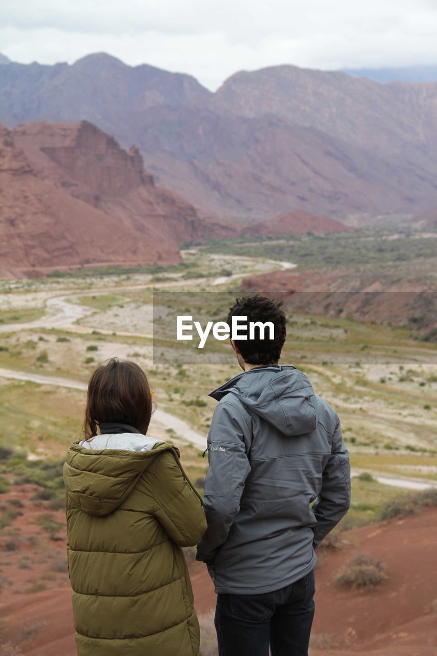 Rear view of couple standing on mountain landscape