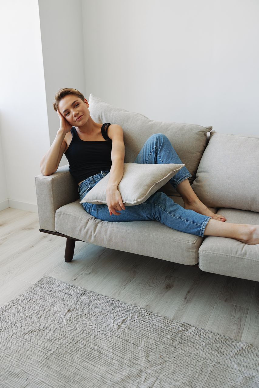 portrait of young woman sitting on sofa at home