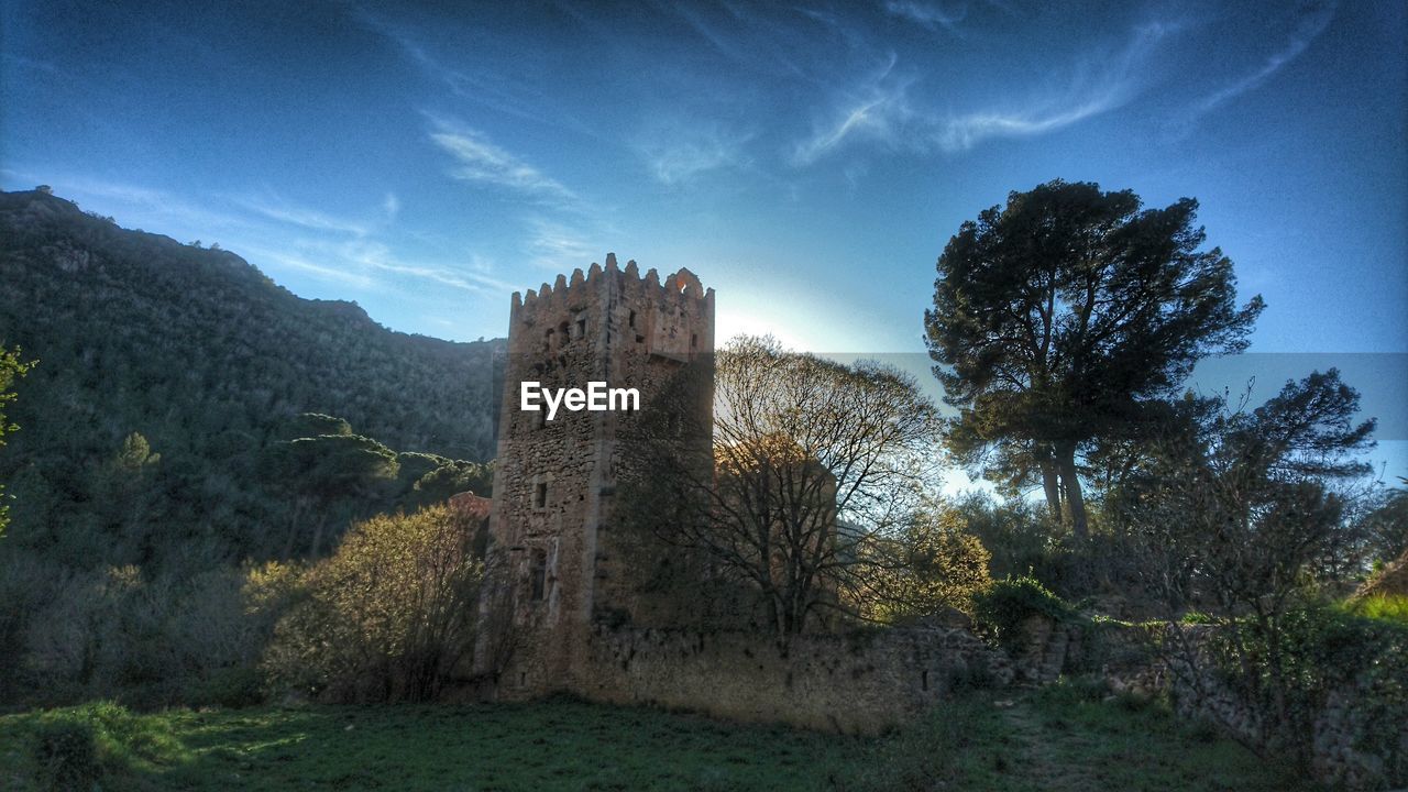 Castle by mountain against sky