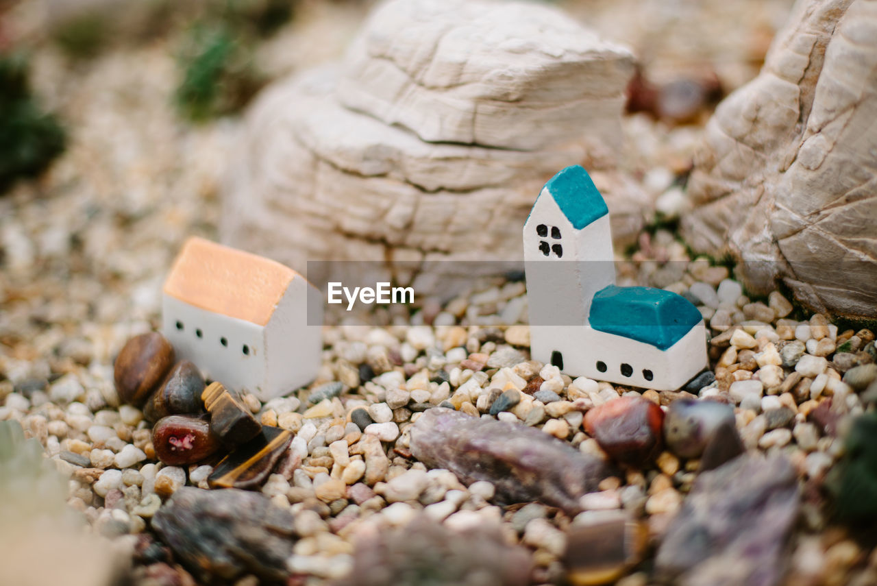 Close-up of model house amidst small rocks