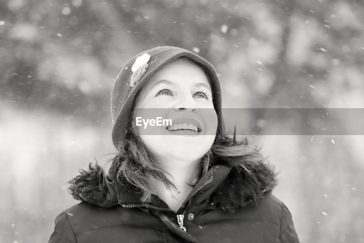 CLOSE-UP PORTRAIT OF SMILING YOUNG WOMAN IN WINTER