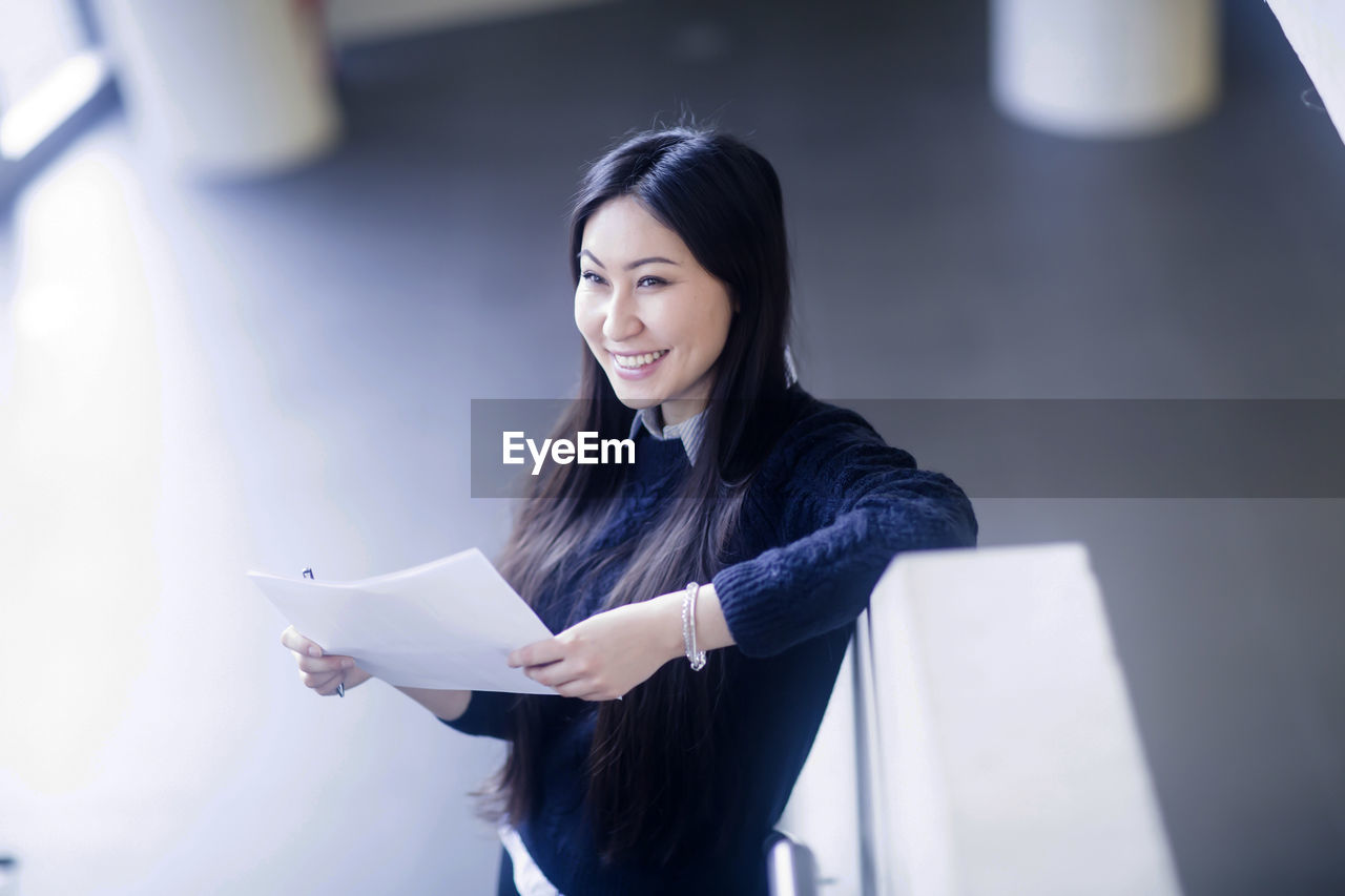 Young asia woman with paper in an office standing with paper