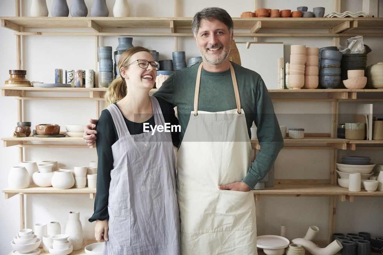 Smiling male and female coworkers in art studio