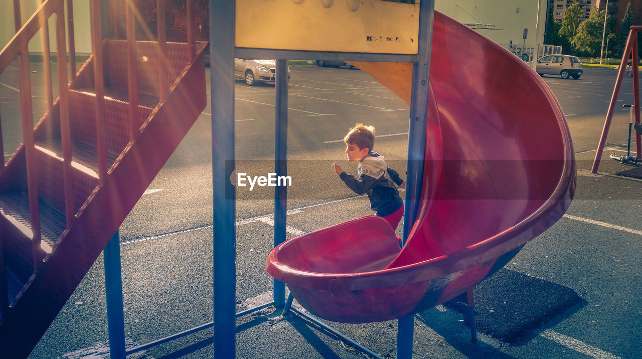 Boy running by slide at playground