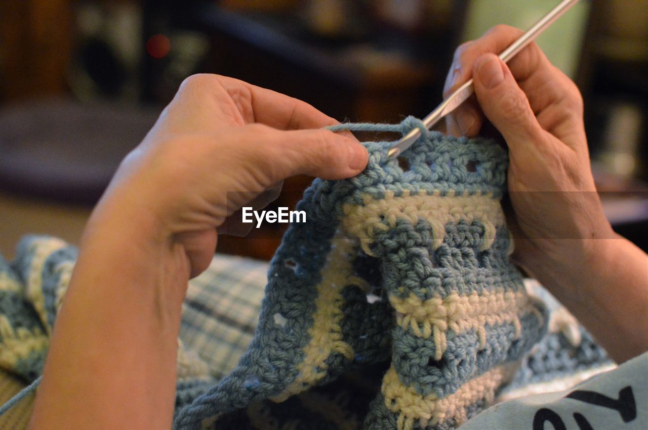 Close-up of hands crocheting at home