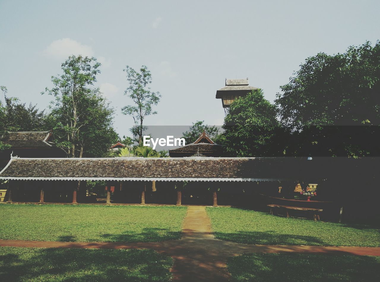 VIEW OF BUILT STRUCTURE WITH TREES IN FOREGROUND