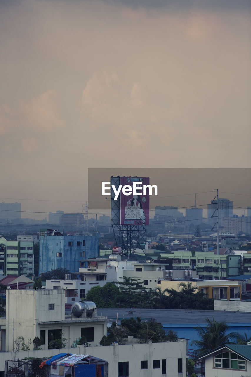 HIGH ANGLE VIEW OF BUILDINGS AGAINST SKY AT SUNSET