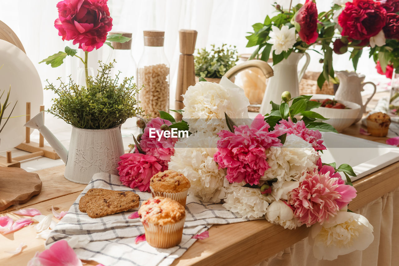 The kitchen countertop is decorated with peonies. the interior is decorated with spring flowers.