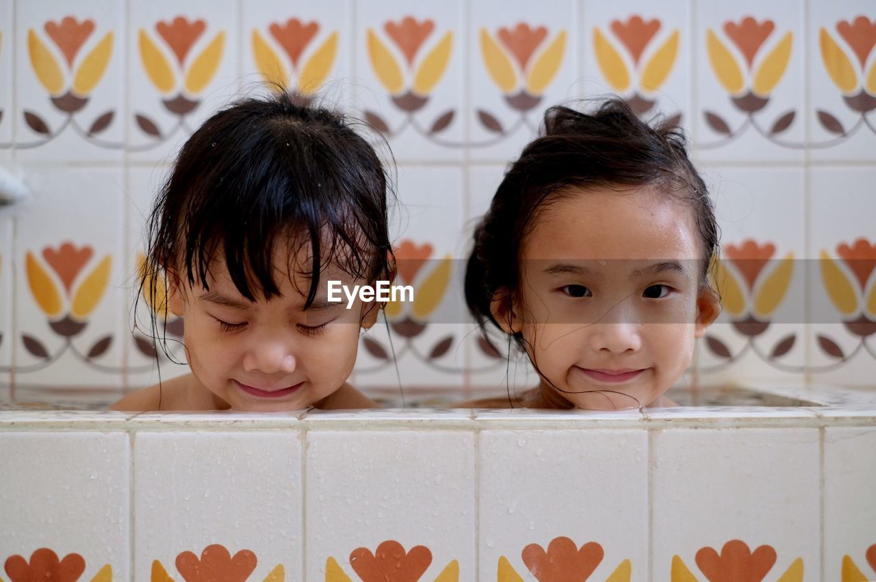 Siblings bathing in tub at home 