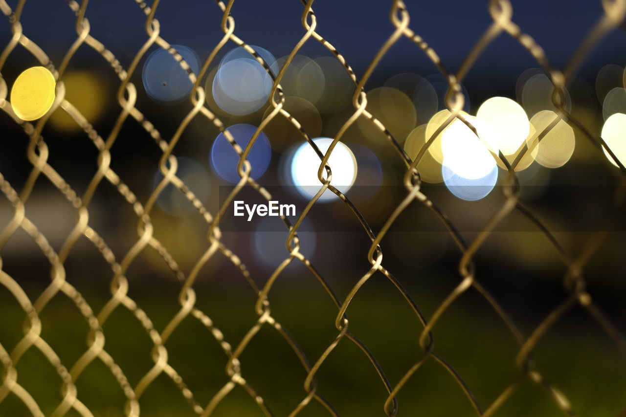 Close-up of chainlink fence at night