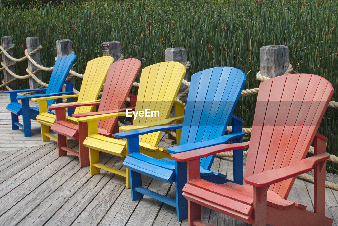 EMPTY CHAIRS AND TABLES ON GRASS
