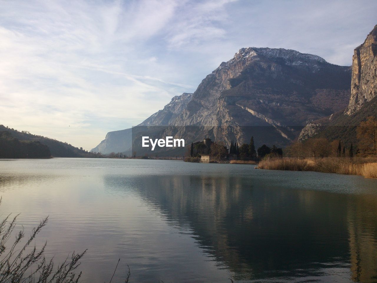 Scenic view of lake by mountains against sky and castle