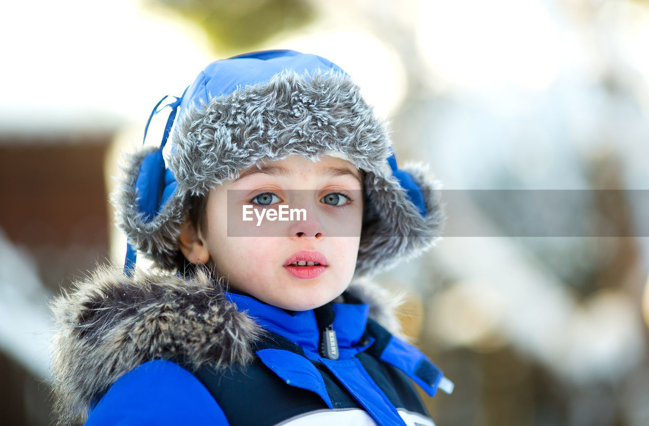 Portrait of a boy 6 years old in warm clothes in winter
