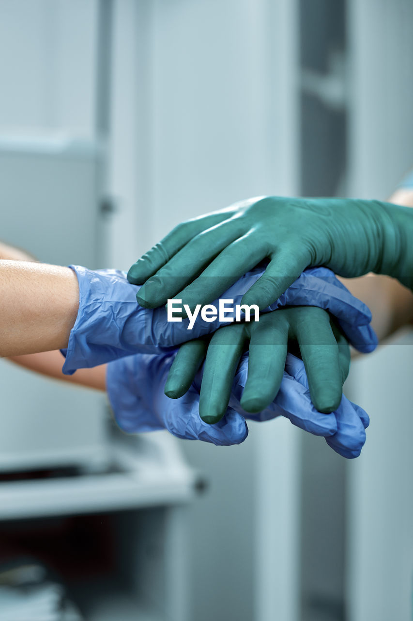 Cropped image of doctors stacking hands at hospital