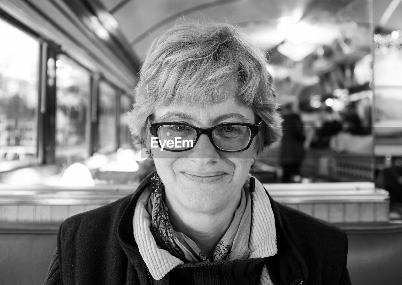 Portrait of smiling woman wearing eyeglasses at restaurant