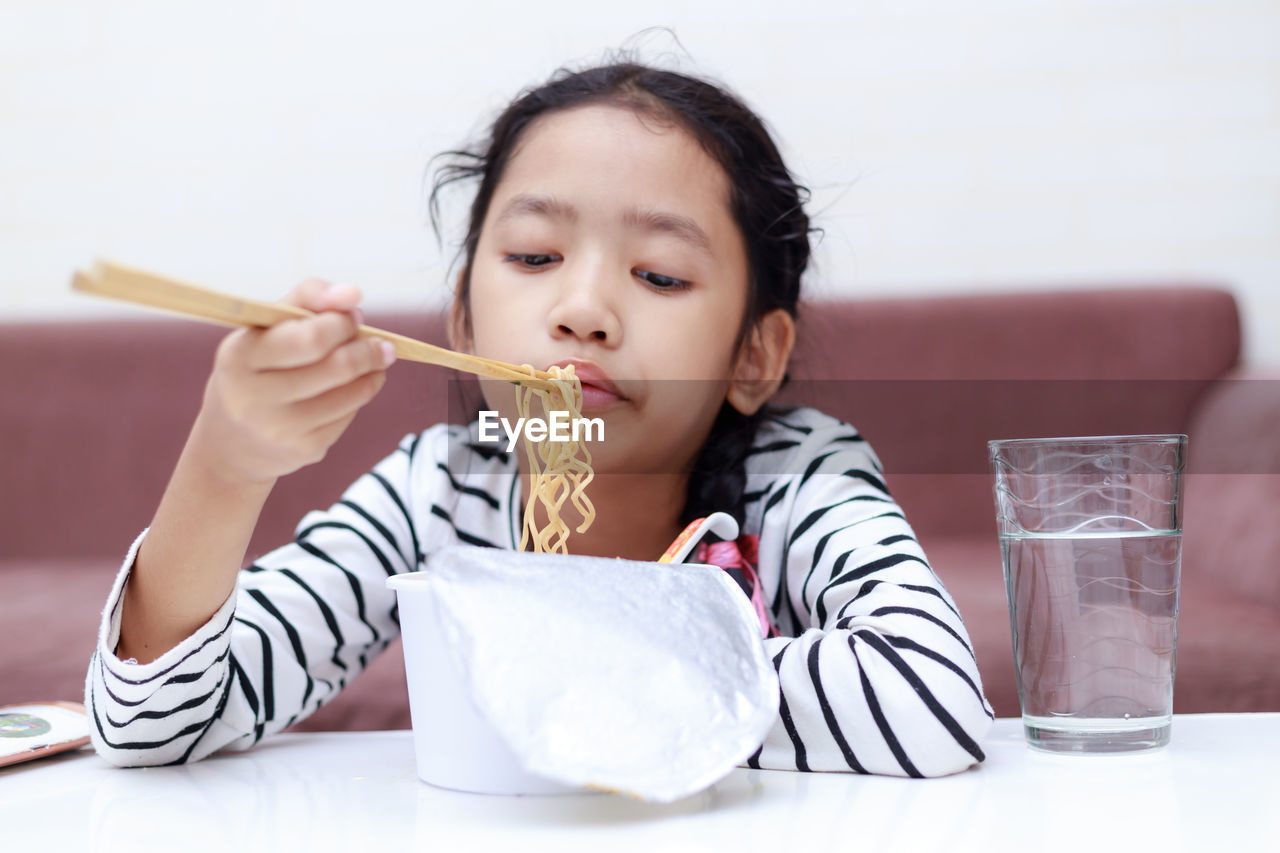 PORTRAIT OF A GIRL HOLDING ICE CREAM IN GLASS TABLE