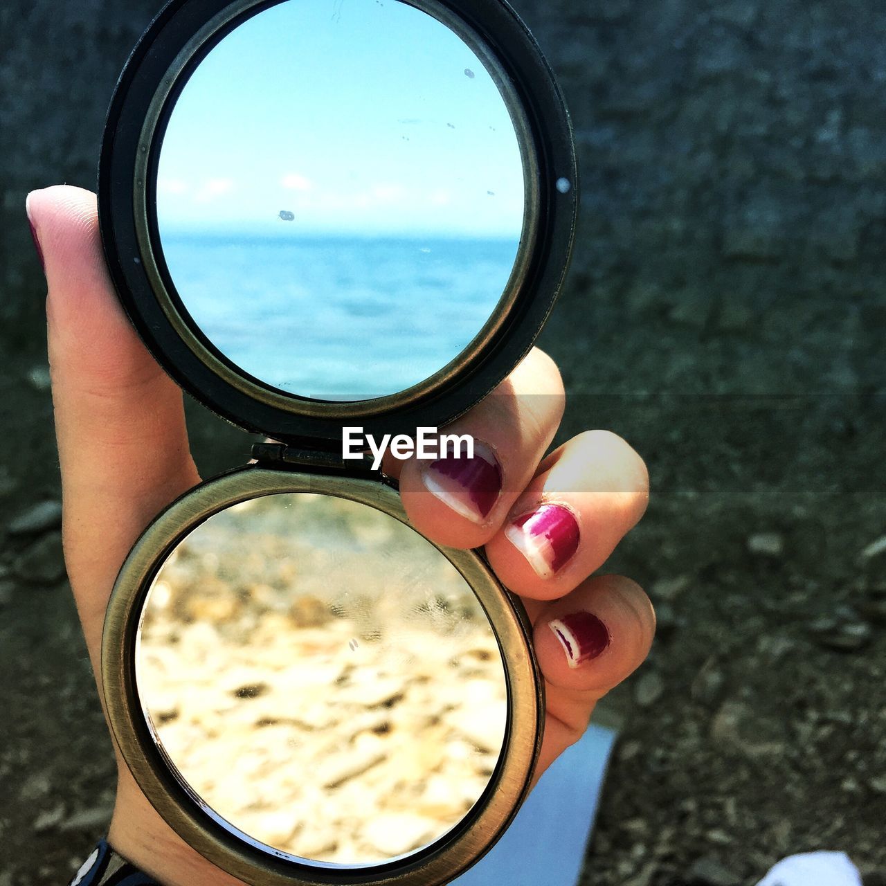 Cropped hand of woman holding hand mirror