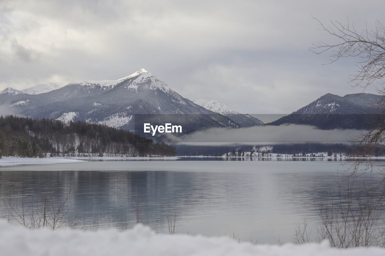 Scenic view of lake and snowcapped mountains against sky