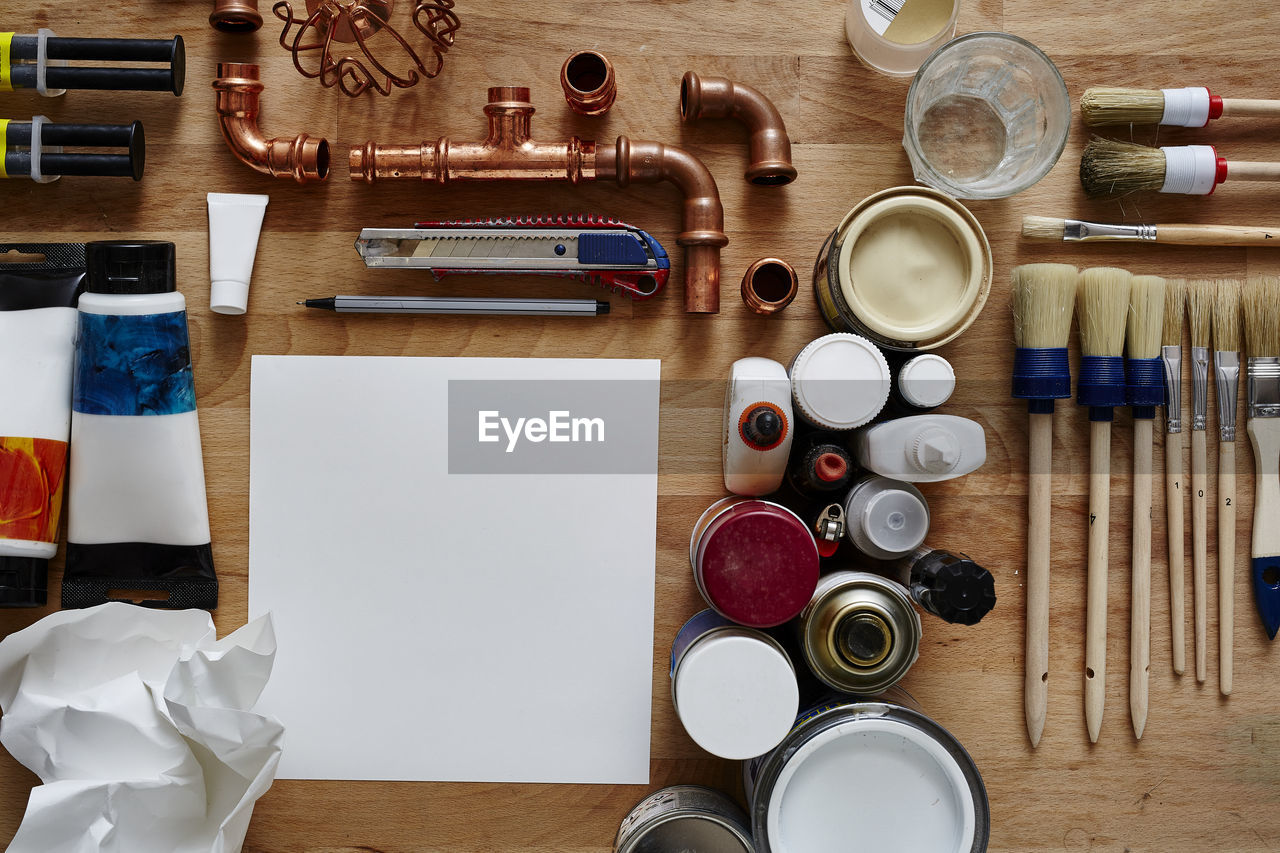 Directly above shot of work tools and plumbing equipment on wooden table