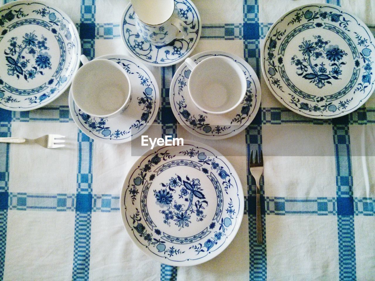 Directly above shot of plates and tea cups arranged on table