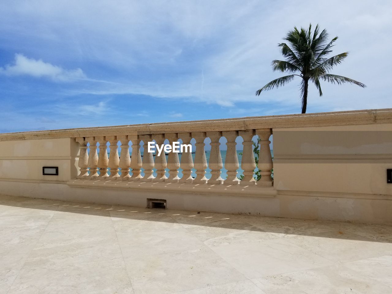 BUILT STRUCTURE BY PALM TREES AGAINST SKY