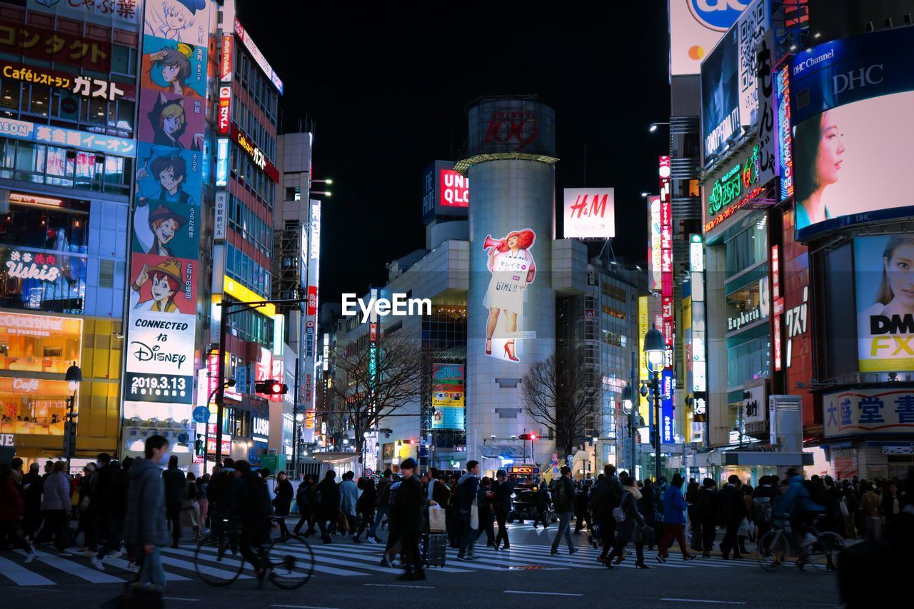 People walking on city street at night