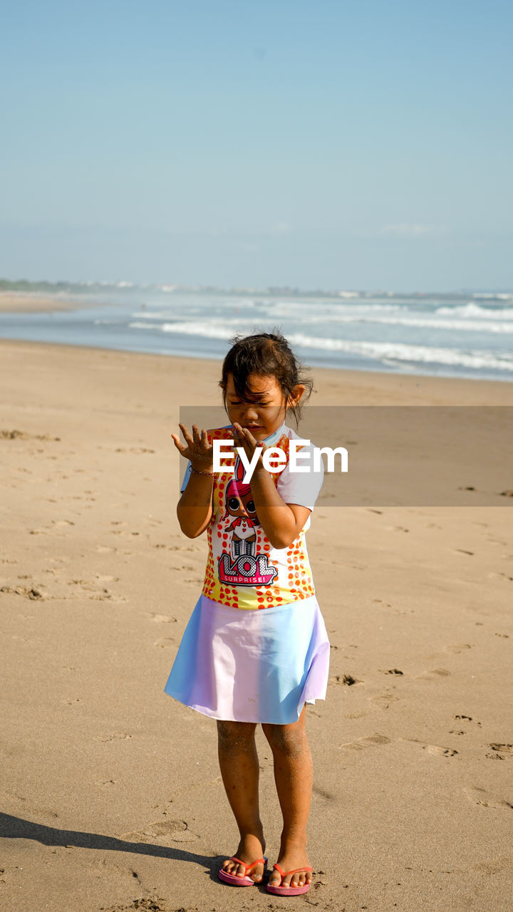 A little girl is playing on the beach