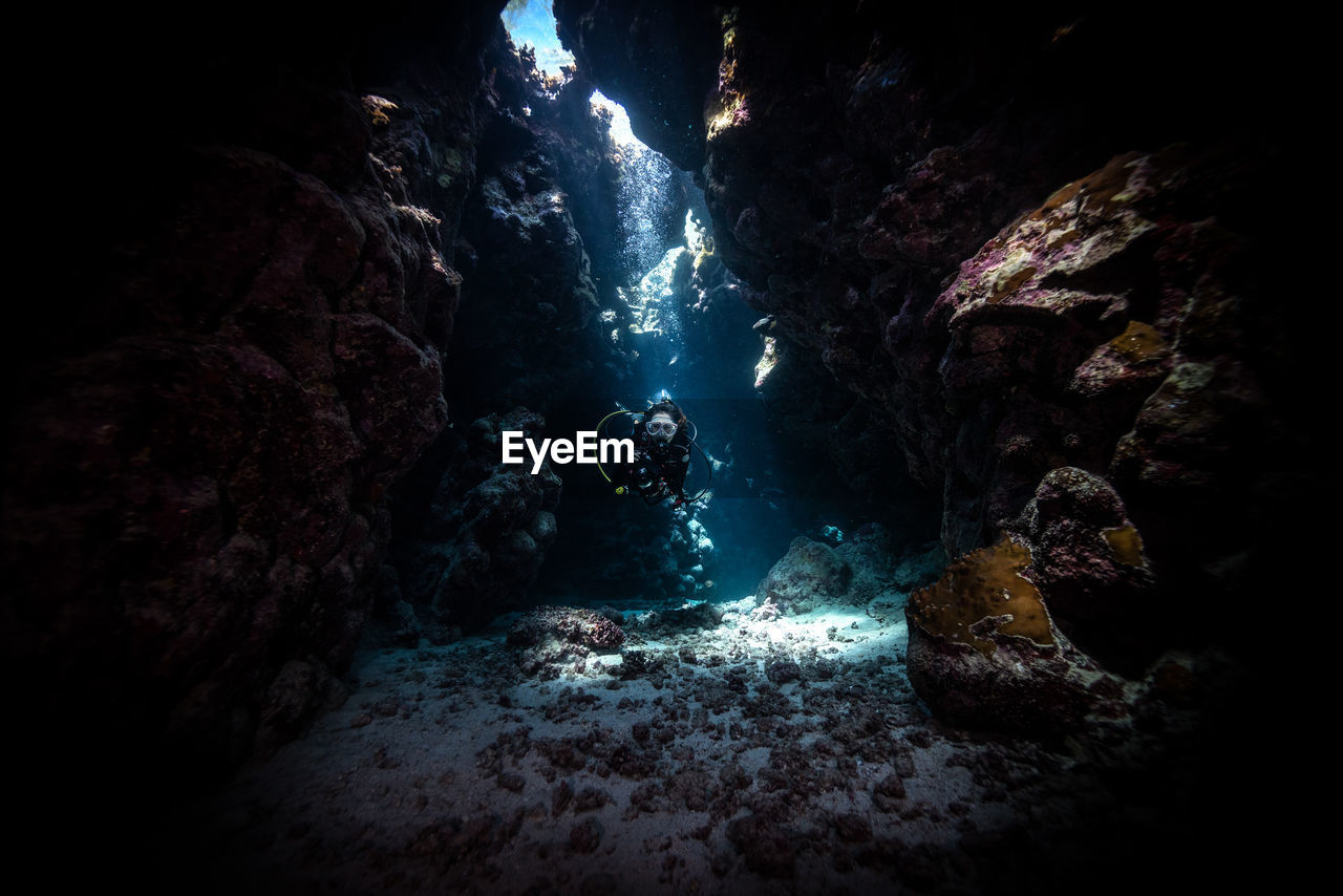 Sunlight falling on man scuba diving at red sea