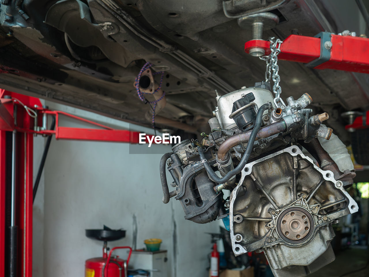 vehicle, engine, mode of transportation, transportation, indoors, industry, aircraft engine, auto part, automobile repair shop, no people, technology, auto repair shop, occupation, equipment, car, red, air vehicle, machinery, mechanic, work tool