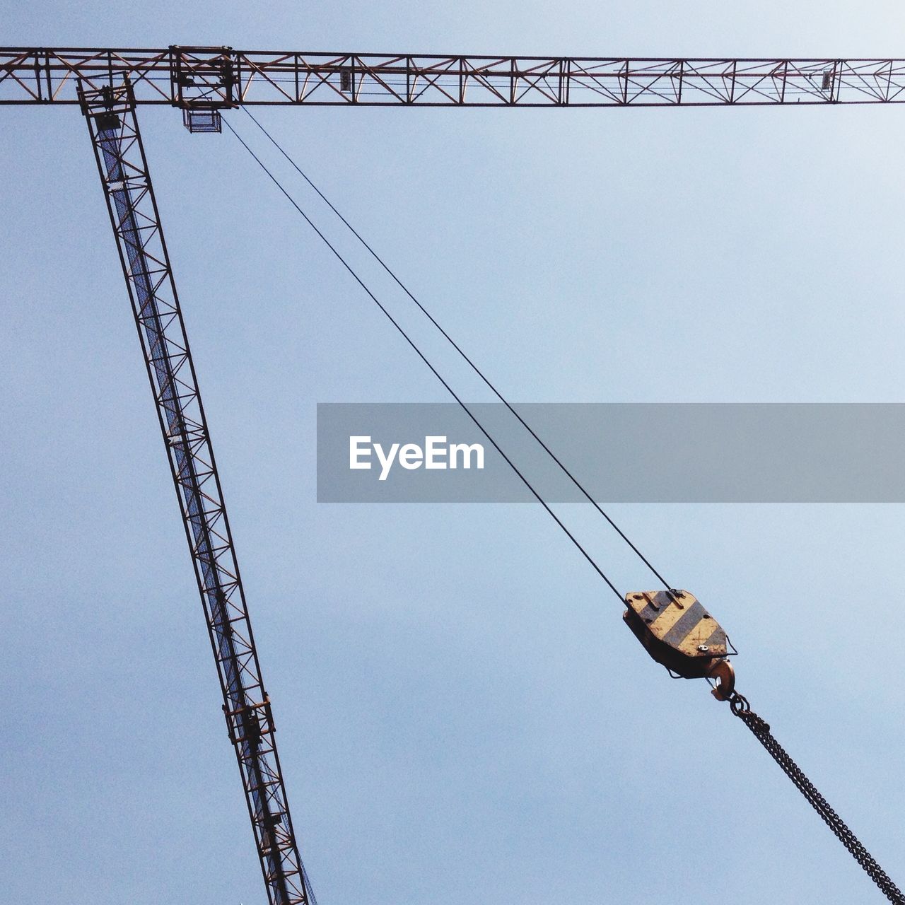 Low angle view of crane against clear sky