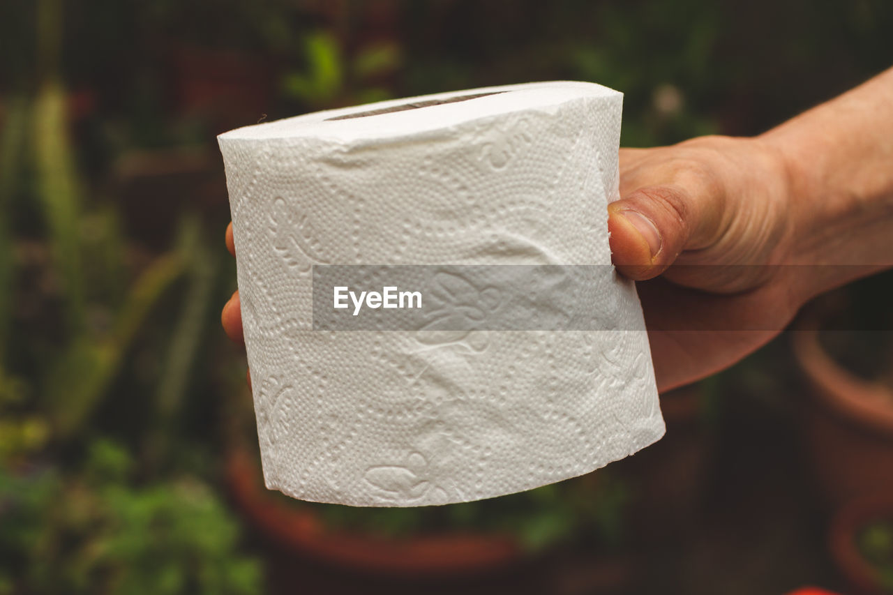 Close-up of hand holding toilet paper