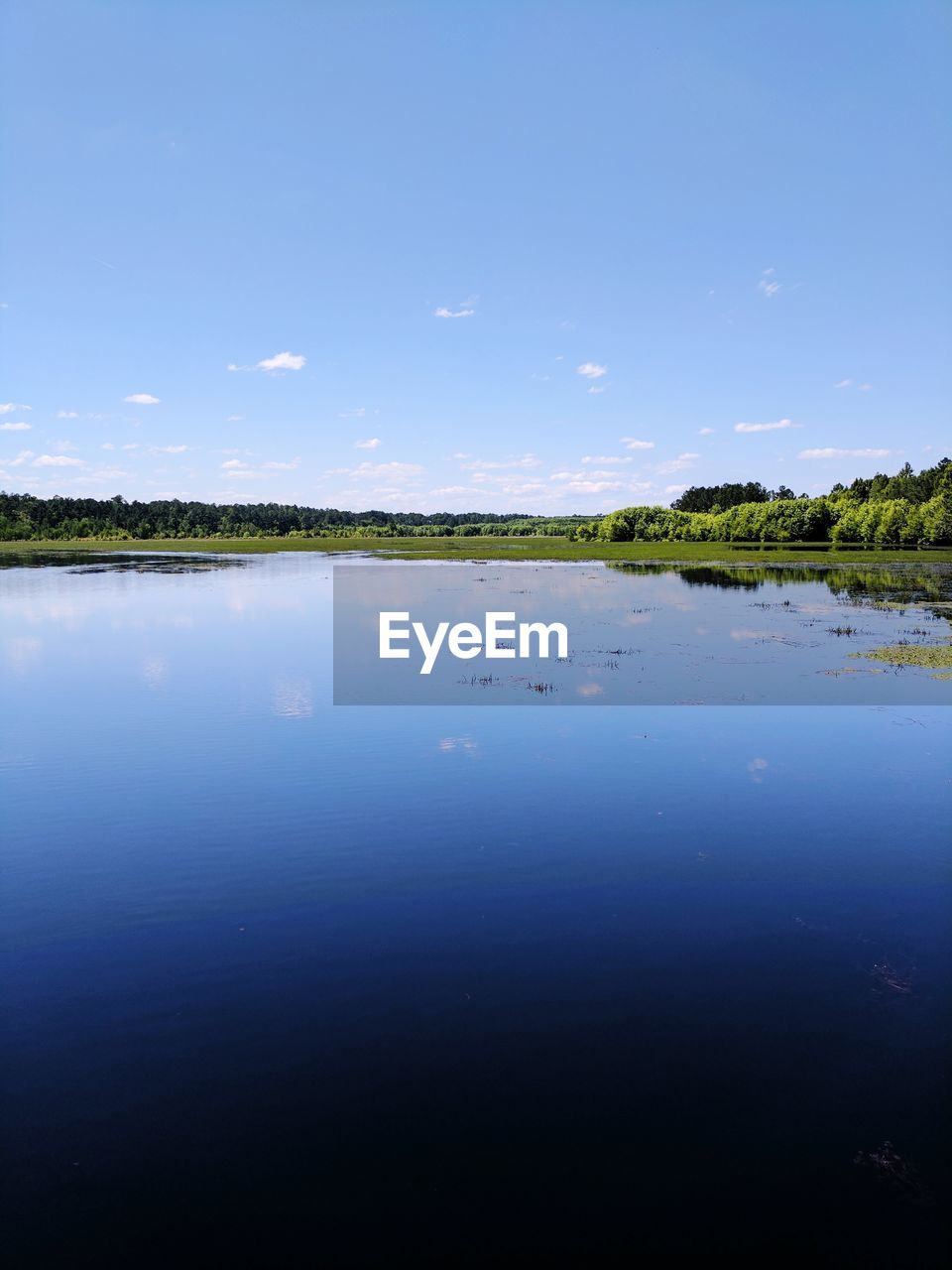 Scenic view of lake against blue sky