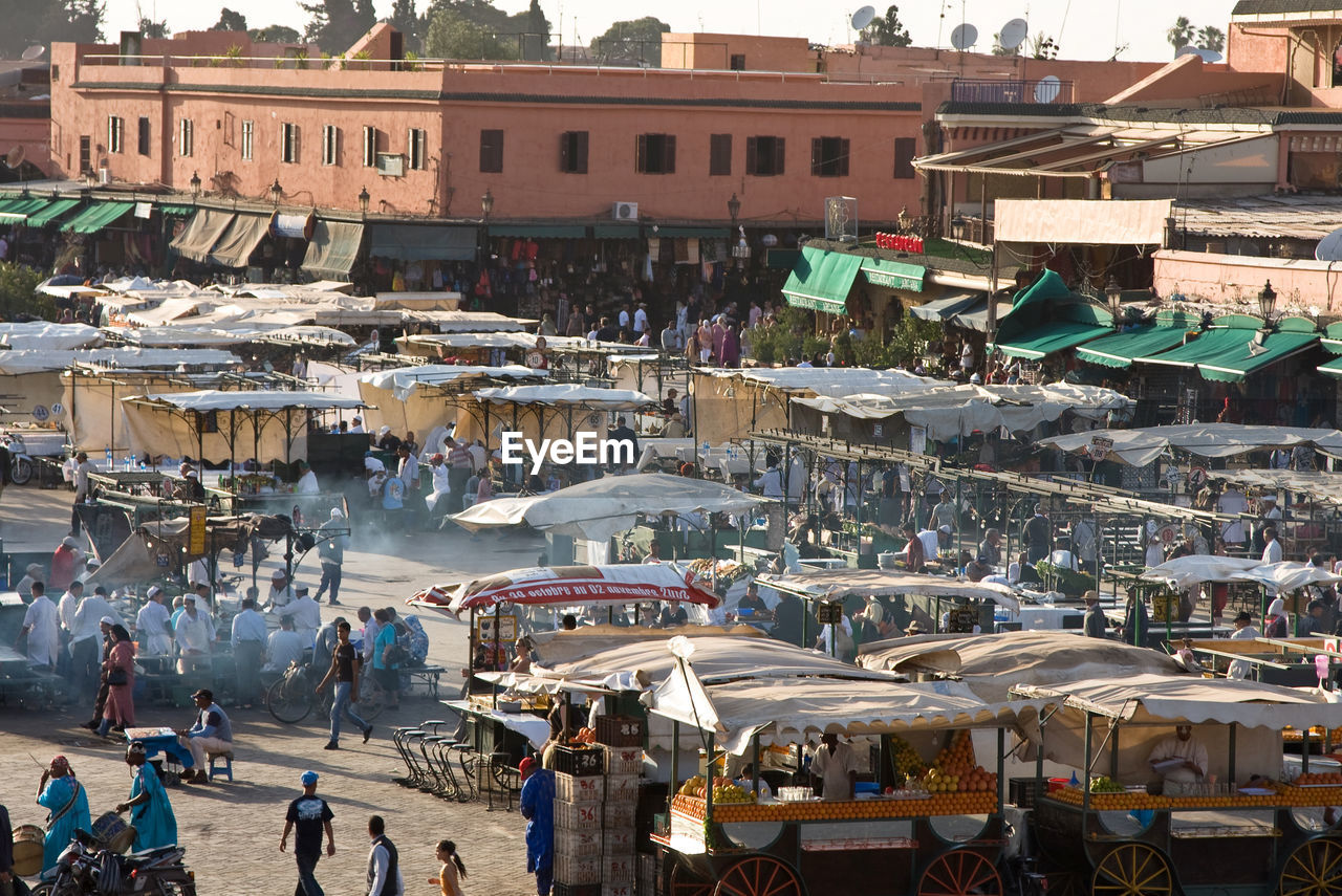 HIGH ANGLE VIEW OF PEOPLE AT MARKET STALL