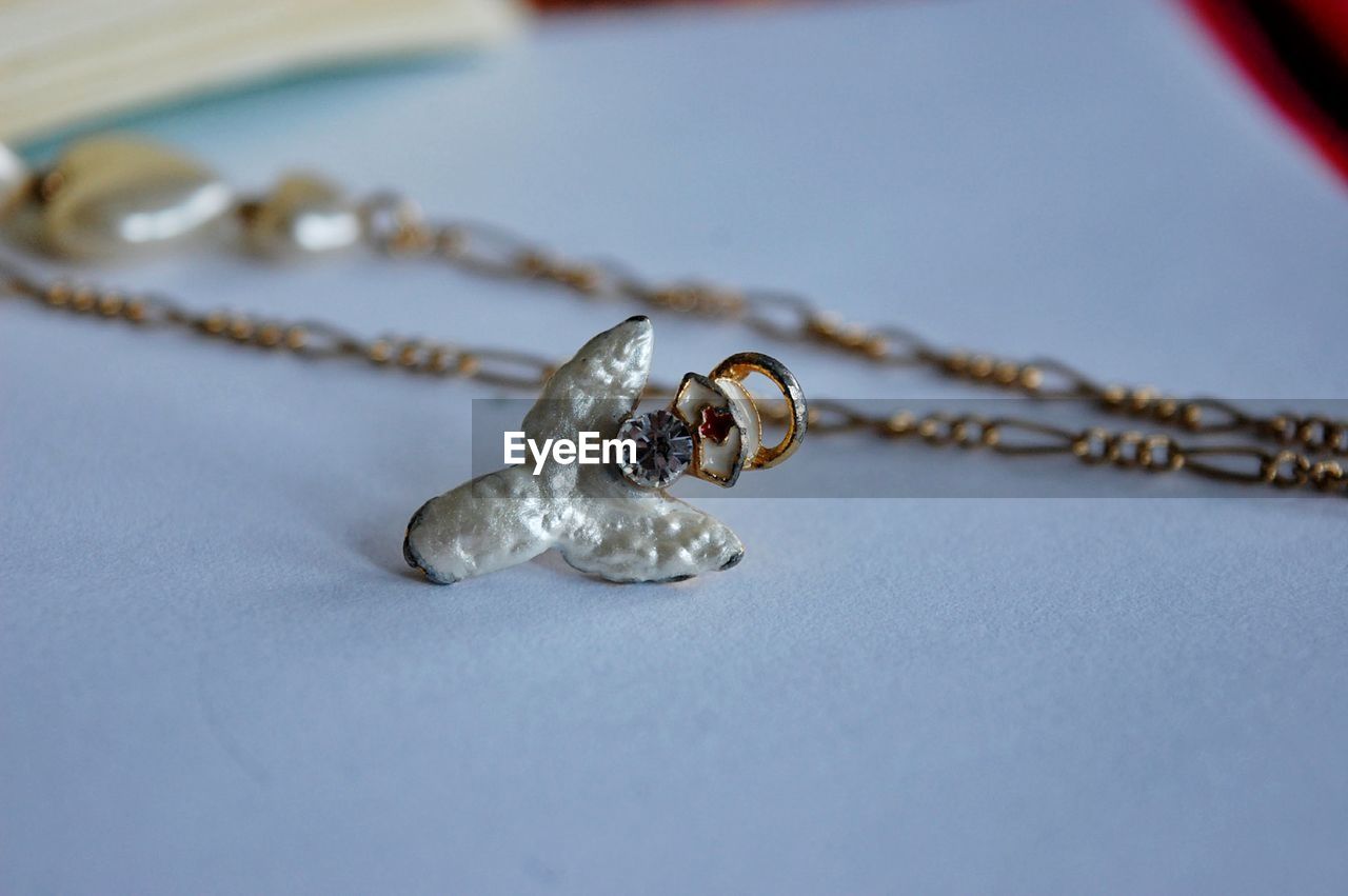 Close-up of necklace and pendant on table