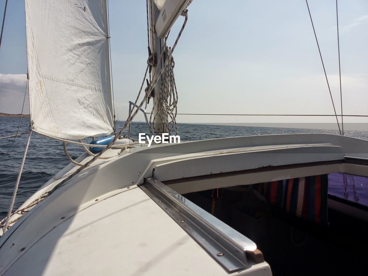 CLOSE-UP OF SAILBOAT IN SEA AGAINST SKY