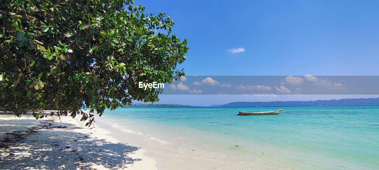 water, sea, land, beach, sky, tree, beauty in nature, nature, travel, scenics - nature, tropical climate, travel destinations, sand, vacation, trip, holiday, plant, island, tranquility, body of water, tourism, blue, shore, idyllic, tranquil scene, environment, lagoon, turquoise colored, summer, coastline, ocean, nautical vessel, sunlight, sunny, tropical tree, tropics, outdoors, palm tree, cloud, coast, landscape, seascape, arriving, day, relaxation, horizon over water, transportation, no people, water's edge, horizon, clear sky, non-urban scene, tourist resort, honeymoon, sun, bay of water, coconut palm tree, bay, reef, sports, journey, wave, coral