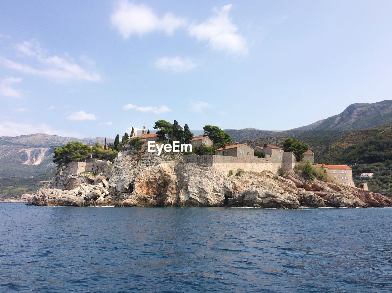 Scenic view of sea by buildings against sky