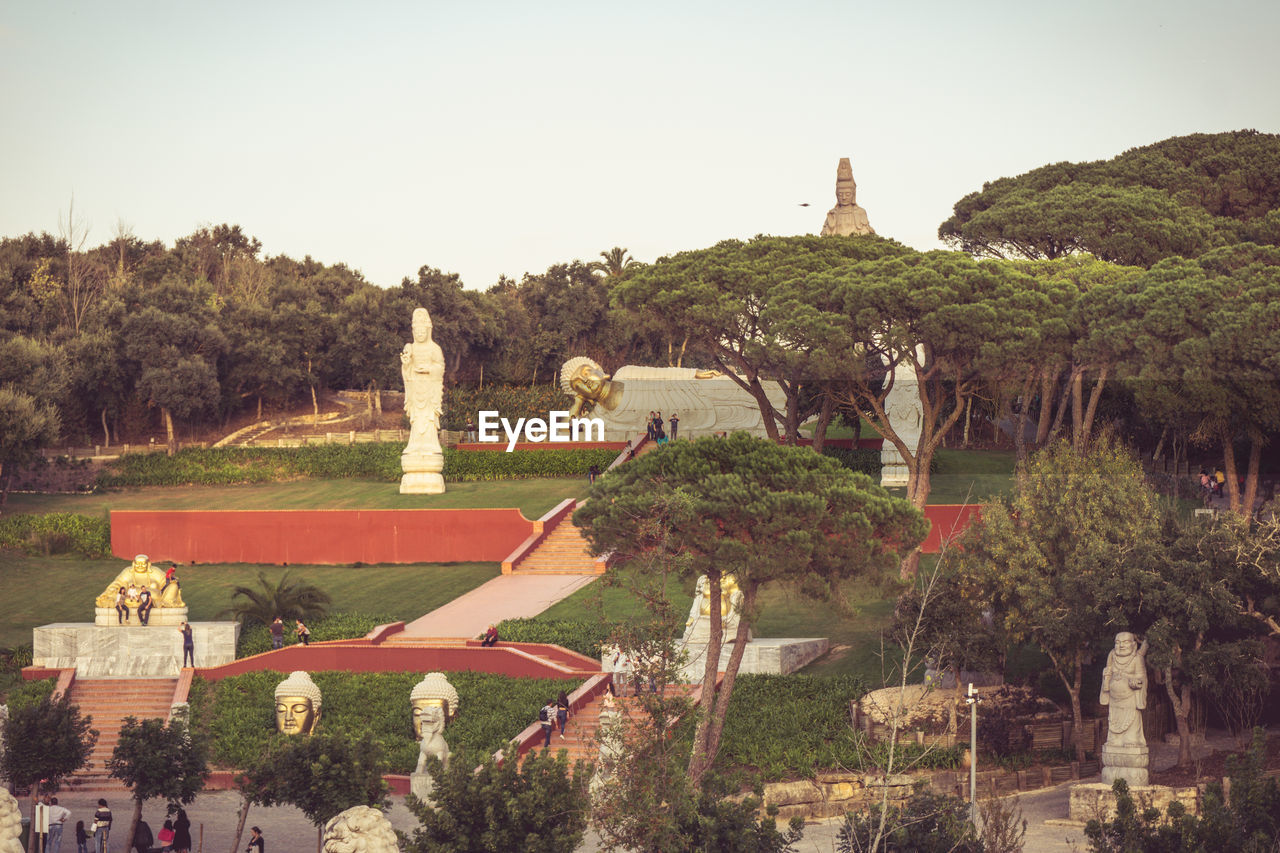 STATUE AGAINST TREES AND PLANTS