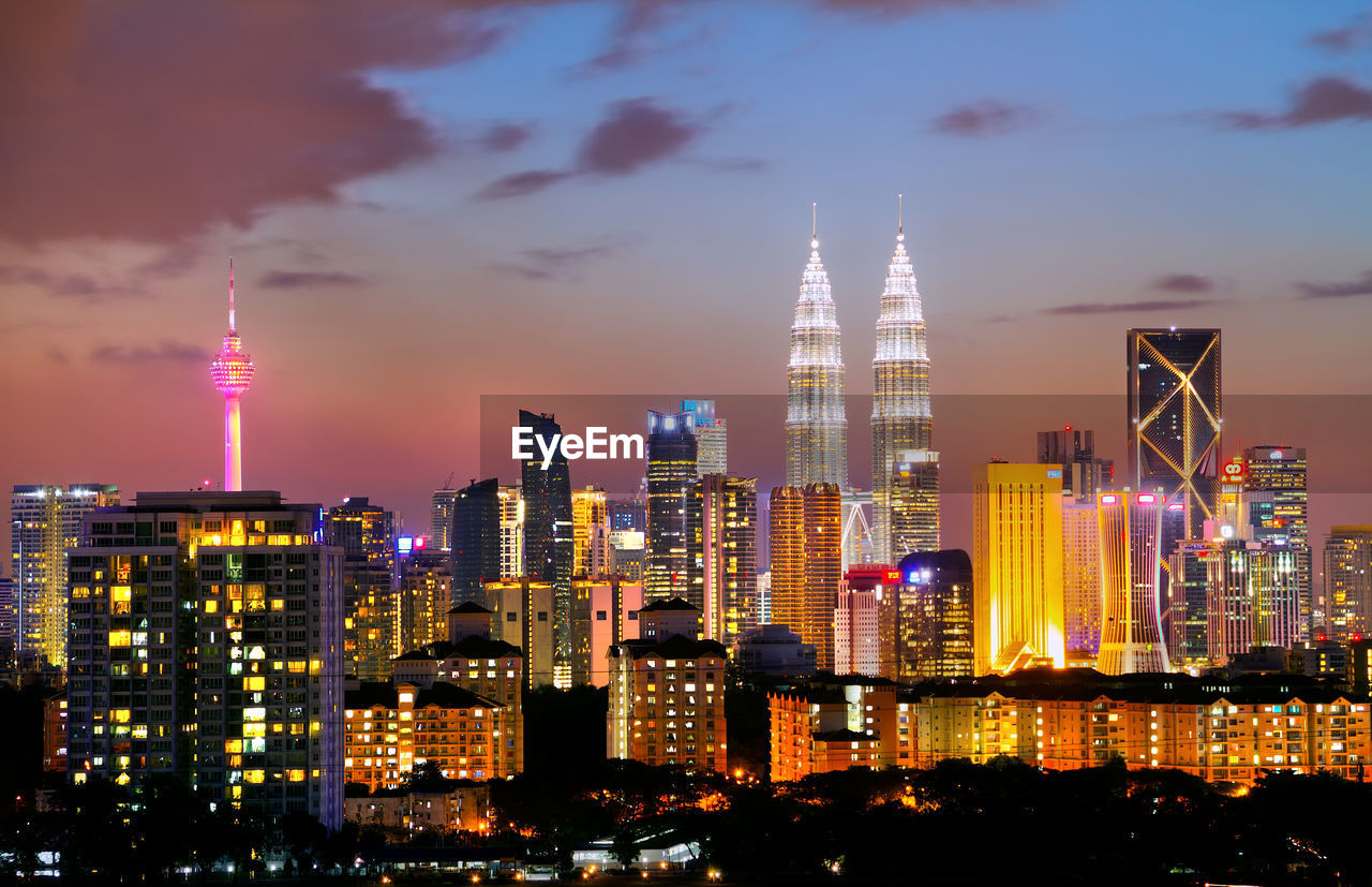 Illuminated cityscape against sky at night