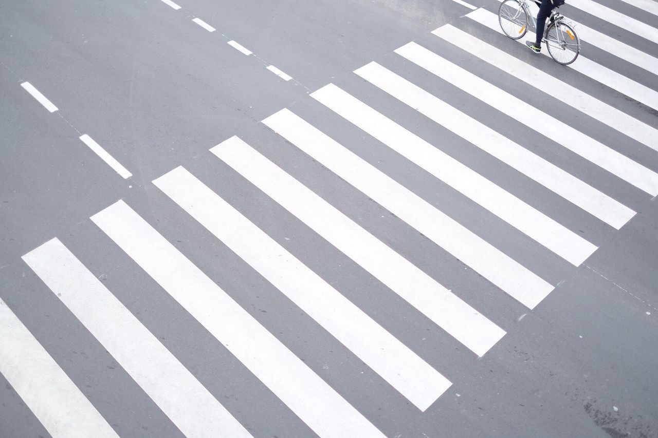 LOW SECTION OF PERSON WALKING ON ZEBRA CROSSING