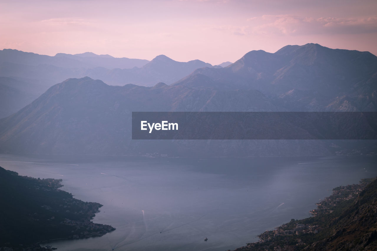 Scenic view of lake and mountains against sky during sunset