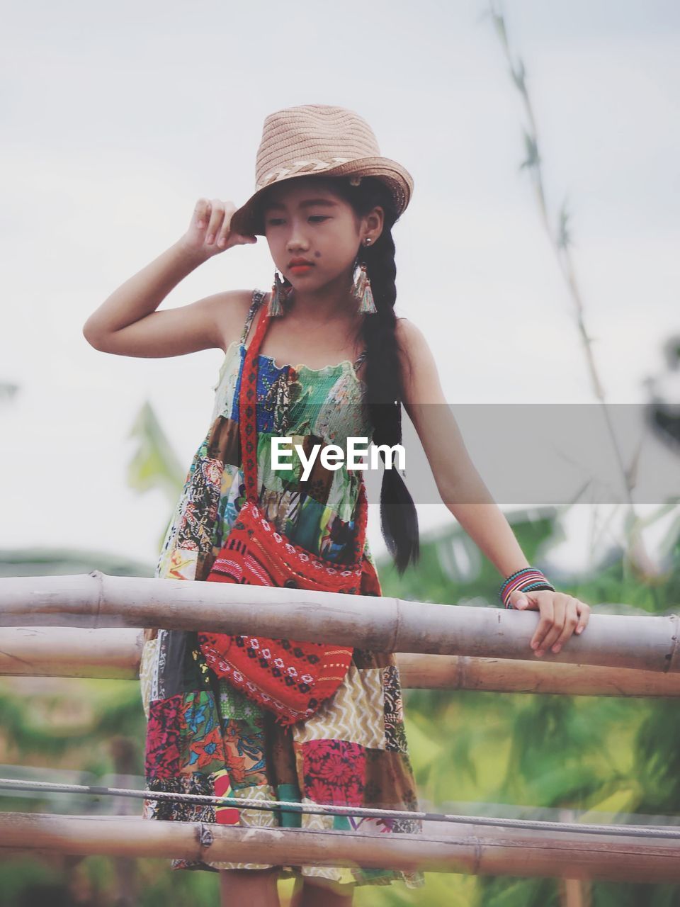 Girl looking away while standing against railing