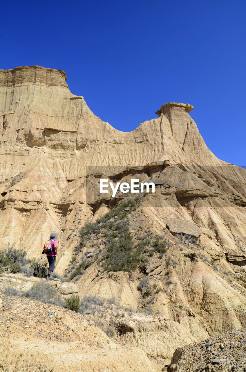 REAR VIEW OF ROCK FORMATIONS AGAINST CLEAR SKY