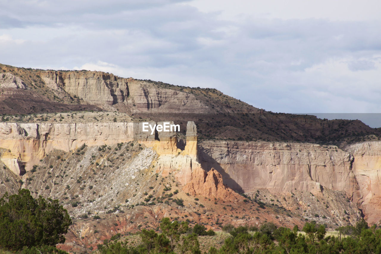 High angle view of rocky mountains against cloudy sky